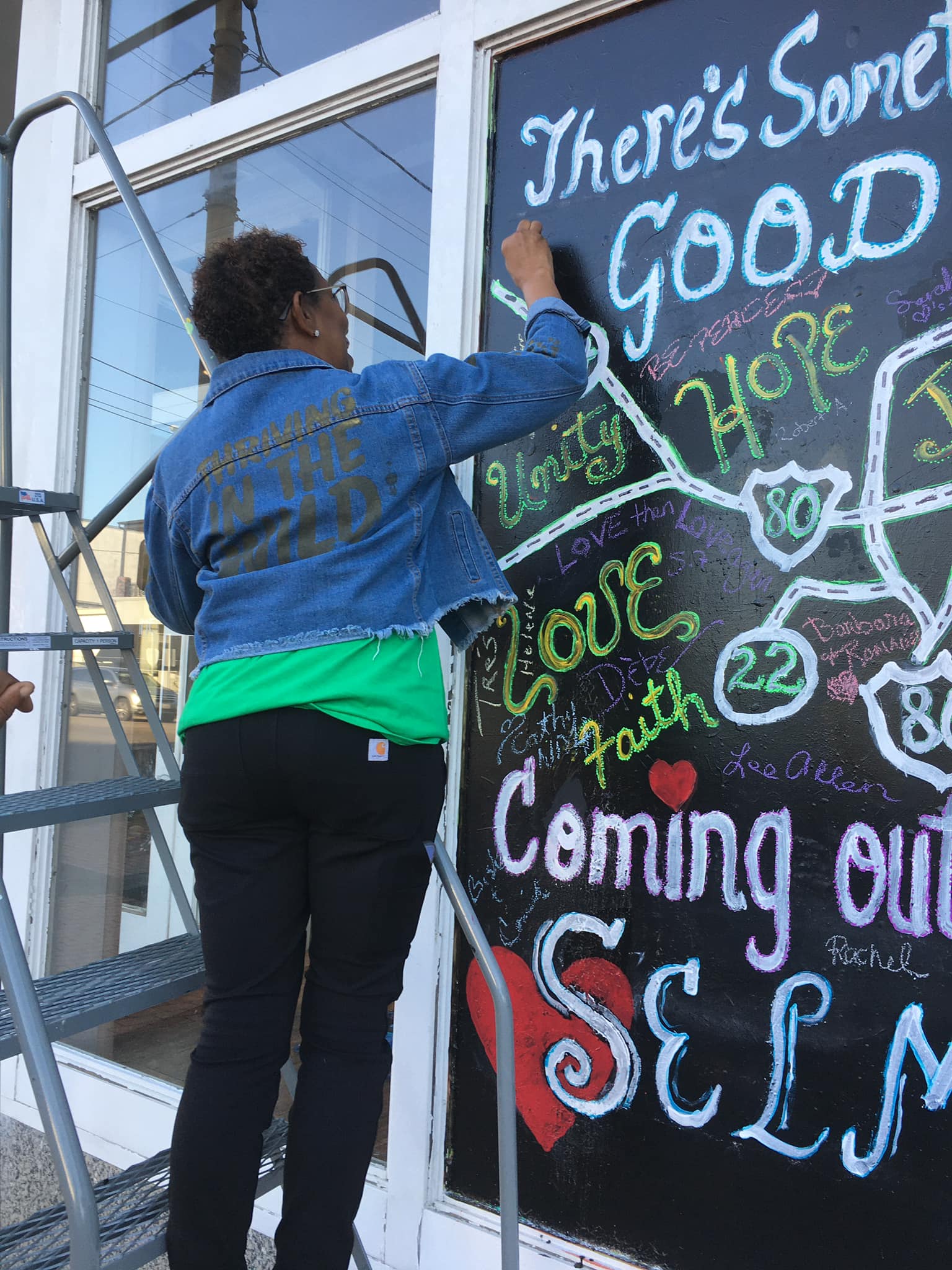 Woman writing on chalkboard window painting