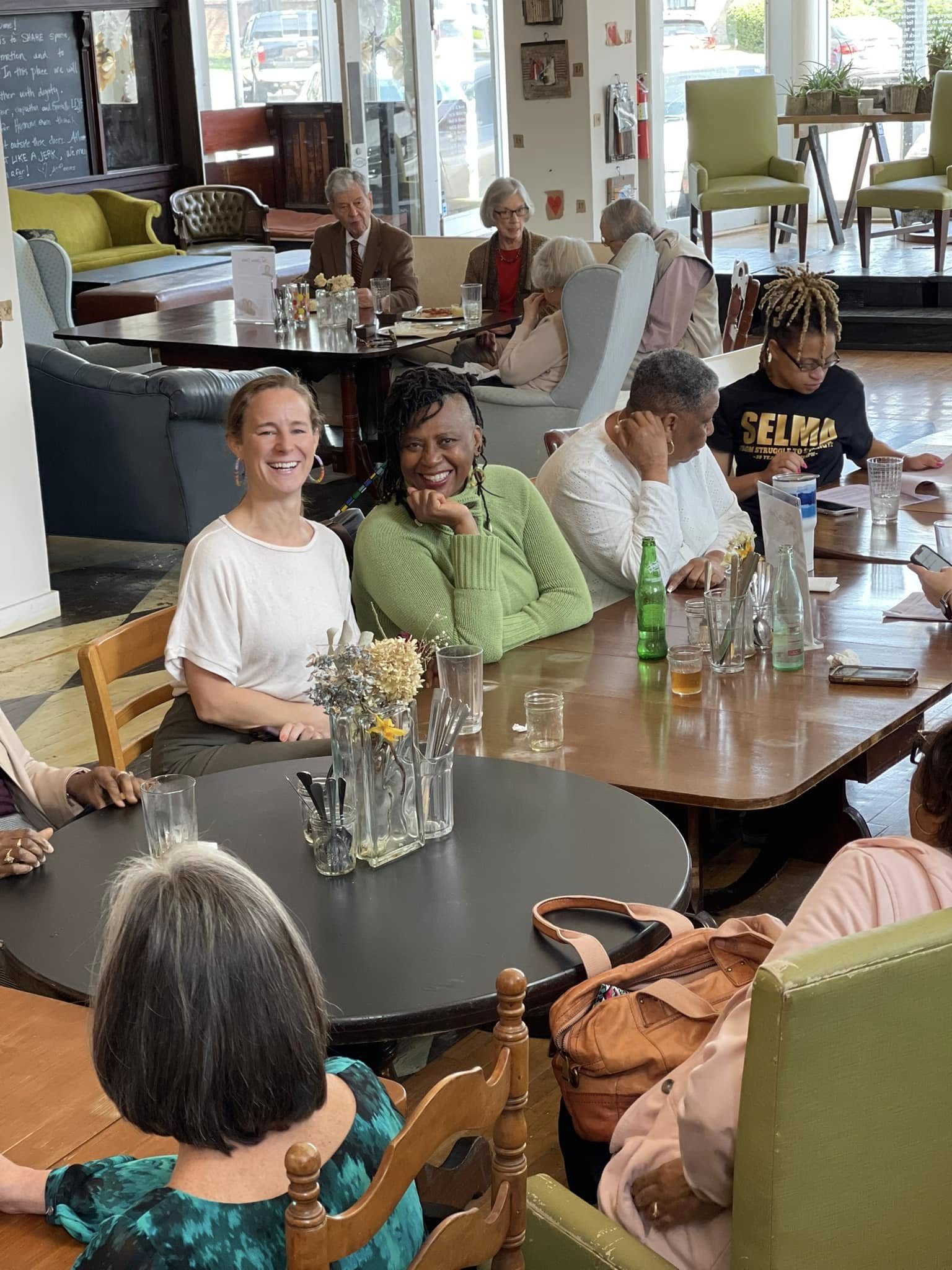 People sitting family style  at a table and laughing