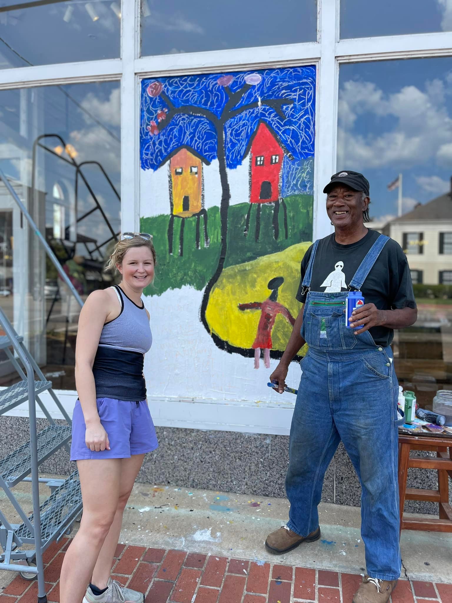 Lizzie Reeves and Charlie Lucas in front of painted window