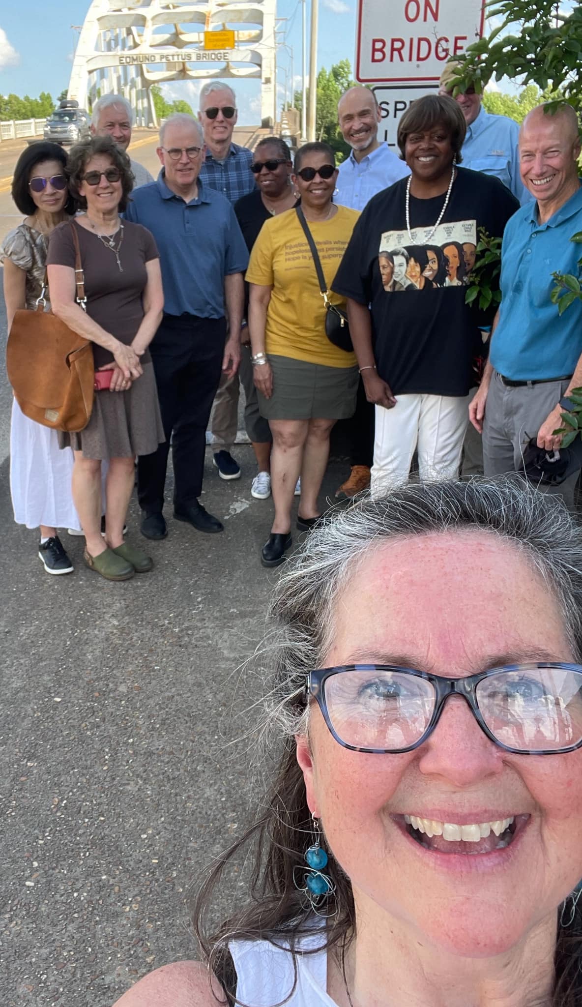 AC and a group tour posing in front of the Edmund Pettus Bridge